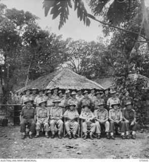 Outdoors group portrait of twenty four personnel of the Deputy Director of Ordnance Services, Headquarters, New Guinea Force. Identified, back row, left to right: VX72878 Corporal (Cpl) H J King ..