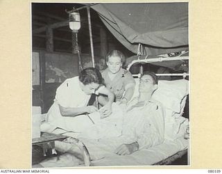 LAE, NEW GUINEA. 1944-08-02. NFX138789 SISTER J.M. COOPER (1), WITH QFX40938 SISTER M.E. DRAKE (2), ADMINISTERING INTRAVENOUS SALINE TO A PATIENT AT THE 2/7TH GENERAL HOSPITAL, AUSTRALIAN ARMY ..