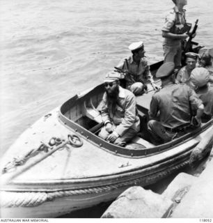 MENADO, CELEBES. 1945-09-15. WO YAMADA, IMPERIAL JAPANESE ARMY, CONTROLLER OF THE AIRMEDIDE WOMEN'S CAMP (A SUSPECTED WAR CRIMINAL) ABOARD A MOTOR BOAT ON HIS WAY TO THE RAN VESSEL, HMAS GLENELG ..