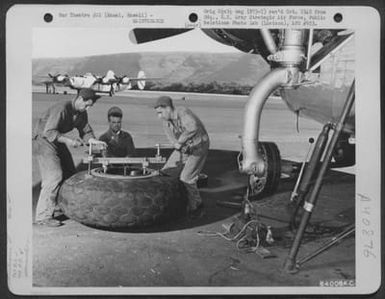 Men Of The 864Th Bomb Squadron, 494Th Bomb Group Change One Of The Big Tires On A Consolidated B-24 Liberator At The Barking Sands Airstrip On Kauai, Hawaii. They Are, Left To Right: Sgt Milton S. Nygaard Of Salem, Oregon; Tsgt Merle E. Anderson Of Toll (U.S. Air Force Number 64008AC)