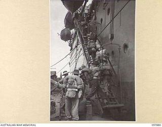 OFF BORAM BEACH, NEW GUINEA. 1945-10-13. THE FIRST BATCH OF TROOPS TO LEAVE THE WEWAK AREA UNDER THE PRIORITY DEMOBILISATION SCHEME WERE MEMBERS OF 6 DIVISION. SHOWN, TROOPS MOVING UP THE GANGWAY ..