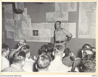 JACQUINOT BAY, NEW BRITAIN. 1945-09-07. MAJOR GENERAL K.W. EATHER, GENERAL OFFICER COMMANDING 11 DIVISION EXPLAINING THE POINTS OF THE SURRENDER OF THE JAPANESE FORCES TO STAFF OFFICERS AT A ..
