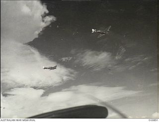 BISMARCK ARCHIPELAGO. 1944-03-28. AIRCRAFT, CODE NAMED UP-C, UP-W, OF NO. 79 (SPITFIRE) SQUADRON RAAF, IN FLIGHT OVER NEW BRITAIN EN ROUTE FROM KIRIWINA TO THE ADMIRALTY ISLANDS. PHOTOGRAPH TAKEN ..
