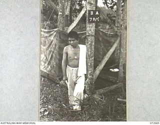 HELDSBACH PLANTATION, NEW GUINEA. 1944-04-06. A JAPANESE PRISONER OF WAR LEAVING THE SHOWER USED BY JAPANESE PRISONERS OF WAR AT THE 106TH AUSTRALIAN CASUALTY CLEARING STATION. THE SIGN TRANSLATED ..