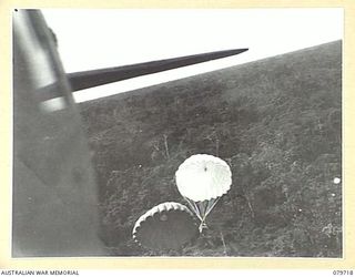 TOROKINA, BOUGAINVILLE, SOLOMON ISLANDS. 1945-03-12. FRESH MEAT SUPPLIES BEING DROPPED FROM A DOUGLAS C47 DAKOTA TRANSPORT AIRCRAFT BY PERSONNEL OF THE 121ST SUPPLY DEPOT PLATOON TO FORWARD TROOPS ..