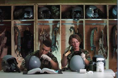 At Andersen Air Force Base (AFB), Guam (GU), US Air Force (USAF) STAFF Sergeant (SSGT) Terilyn Morrison (right) and AIRMAN (AMN) Felipe Maymi-Baez, both life support technicians with the 5th Bomb Wing (BW), Minot Air Force Base (AFB), North Dakota (ND), inspect helmets belonging to B-52 Stratofortress bomber aircraft aircrew members