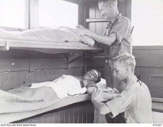 MADANG, NEW GUINEA. 1944-08-18. NX109145 PRIVATE L.C. MARTIN (1) AND VX127194 PRIVATE G.H. RICE (2) MEDICAL ORDERLIES OF THE NEW GUINEA SEA AMBULANCE TRANSPORT COMPANY TREATING PATIENTS ABOARD THE ..