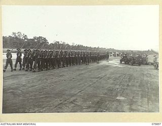 AITAPE, NEW GUINEA. 1945-03-23. A GUARD OF HONOUR DRAWN FROM VARIOUS UNITS OF 6TH DIVISLION TO GREET LORD WAKEHURST, KCMG, GOVERNOR OF NEW SOUTH WALES, MARCH INTO POSITION AT TADJI AIRSTRIP