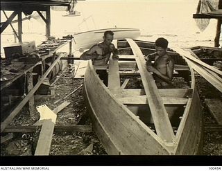 Yule Island, New Guinea. c. 1944-05-15. Private W. Tibbett, shipwright, 1 Marine Food Supply Platoon (left) and George English, known as "boss-boy" building a 20 foot Seine fishing boat