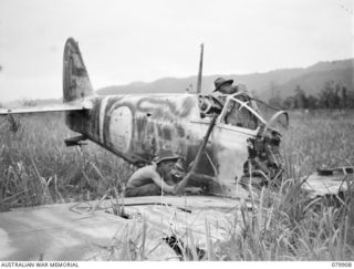DAGUA, NEW GUINEA. 1945-03-25. TROOPS OF THE 2/2 INFANTRY BATTALION EXAMINE A WRECKED JAPANESE FIGHTER AIRCRAFT ON THE AIRSTRIP. IDENTIFIED PERSONNEL ARE:- NX85139 PRIVATE B. BAKER (1); NX126473 ..