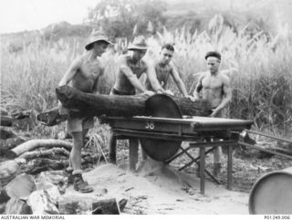 WARDS STRIP, PORT MORESBY, NEW GUINEA, 1943-03. FOUR MEMBERS OF THE RAAF GUIDE A LOG THROUGH A CIRCULAR SAW. WARDS AERODROME WAS WORKED ON BY BOTH NO. 2 AND NO. 5 MOBILE WORKS SQUADRON (LATER ..