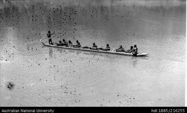 Ten men in long canoe