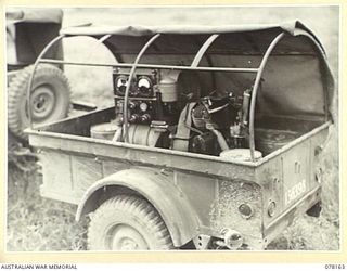 LAE, NEW GUINEA. 1945-01-03. A JEEP TRAILER OF THE 34TH WIRELESS TELEGRAPHY SECTION (HEAVY) LADEN WITH A 5KVA-240 VOLT-50 A, HOWARD MOTOR, PETROL, OIL AND REPAIR KITS. ALL THE EQUIPMENT NEEDED FOR ..