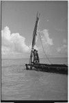 Canoes: men raise sail on an outrigger canoe