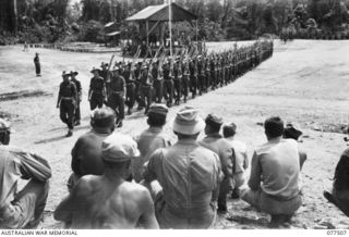 TOROKINA, BOUGAINVILLE ISLAND. 1944-12-06. MEMBERS OF THE 129TH UNITED STATES REGIMENT WATCHING PERSONNEL OF C COMPANY, 15TH INFANTRY BATTALION MARCHING OFF THE PARADE GROUND AFTER AN INSPECTION BY ..