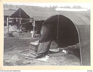 WEWAK AREA, NEW GUINEA. 1945-06-28. SHEDS AT THE FIELD MAINTENANCE CENTRE, ASSISTANT DIRECTOR OF ORDNANCE SERVICE DUMP, HEADQUARTERS 6 DIVISION. MANY OF THE SHEDS WERE CONSTRUCTED WITH THE ..