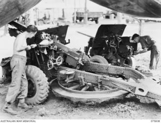 ALEXISHAFEN, NEW GUINEA. 1944-09-13. NX145655 STAFF SERGEANT A.E. HARVEY (1) WORKING ON A 25 POUNDER FIELD GUN AND NX121414 STAFF SERGEANT A.S. WELLS (2) WORKING ON A 2 POUNDER ANTI-TANK GUN IN THE ..