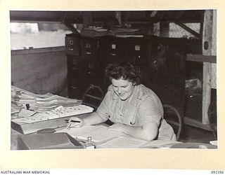 LAE, NEW GUINEA, 1945-05-23. GUNNER E.V. SMITH, AUSTRALIAN WOMENS'S ARMY SERVICE, AT WORK IN THE CENTRAL REGISTRY, 4 ADVANCED ORDNANCE DEPOT. AUSTRALIAN WOMEN'S ARMY SERVICE PERSONNEL ARE AT LAE TO ..