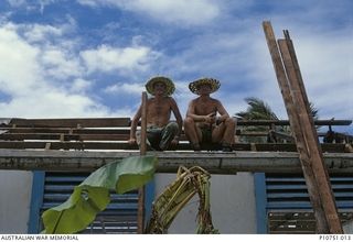 Corporal Steve Thomas and Sapper Ted Cherry repairing a roof of the local school at Pangi village, Lifuka Island. This image relates to the service of Michael Church, 17 Construction Squadron, who ..