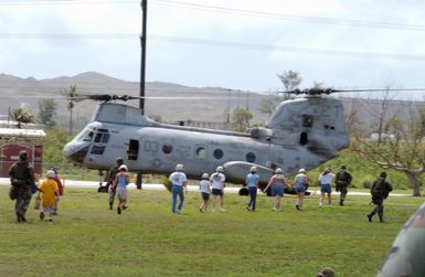 Civilian evacuees board a US Marine Corps (USMC) CH-46 Sea Knight helicopter, Marine Medium Helicopter Squadron 262 (HMM-262), Futenma, Japan, during a simulated non-combatant evacuation operation (NEO) at US Naval Forces Marianas Support Activity, Guam. The simulated NEO is part of Exercise TANDEM THRUST 2003, a joint military endeavor including forces from the United States, Canada and Australia