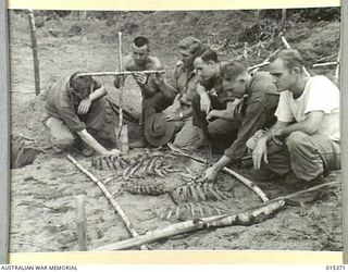 1943-07-31. ALLIED CAPTURE OF MUBO. AUSTRALIAN AND AMERICAN SOLDIERS MARKING THE GRAVE OF AN RAAF PILOT, KILLED DURING THE ALLIED ADVANCE ON MUBO. (NEGATIVE BY G. SHORT)