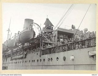 JACQUINOT BAY, NEW BRITAIN. 1945-09-09. 5 YEAR RELEASE PERSONNEL OF 6 DIVISION, LEANING OVER THE RAIL OF THE TROOPSHIP KATOOMBA. THE TERM "5 YEARS RELEASE" REFERS TO THE OPTION OF DISCHARGE GIVEN ..