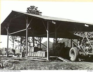 LAE, NEW GUINEA. 1944-03-30. PERSONNEL AT THE JEEP DETAIL ISSUE STORE, NO. 1 SUB DEPOT, 103RD FIELD AMMUNITION DEPOT, OPERATING A "STECO" 2 TON MOBILE CRANE TO LIFT A JEEP ASSEMBLY INTO THE STORE