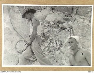 PORT MORESBY, NEW GUINEA. 1943-06-26. ENGINEERS OF THE 5TH AUSTRALIAN EMPLOYMENT COMPANY DRILLING CHARGE HOLES IN QUARRY FACE WITH PNEUMATIC DRILLS. LEFT TO RIGHT:- NX168787 SAPPER J.W. RIORDEN AND ..