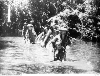 New Guinea. November 1942. Australian troops of the 7th Division, AIF, cross a stream during their advance towards the Japanese occupying Buna
