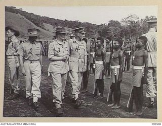 NEAR NADZAB, NEW GUINEA. 1945-03-26. LADY WAKEHURST (3), ACCOMPANIED BY LIEUTENANT GENERAL V.A.H. STURDEE (4), INSPECTING C COMPANY, 2 NEW GUINEA INFANTRY BATTALION AT CAMP DIDDY. IDENTIFIED ..