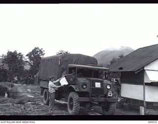 RABAUL, NEW BRITAIN, 1946-03-27. PRIVATE S.L. ALBOM TAKING DELIVERY OF COPIES OF THE LATEST EDITION OF THE ARMY NEWSPAPER GUINEA GOLD FOR DISTRIBUTION TO UNITS IN 8 MILITARY DISTRICT AREA