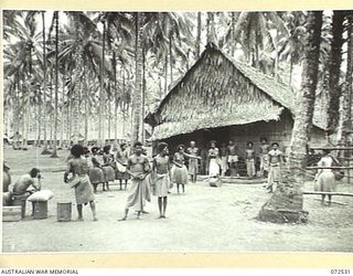MILNE BAY, NEW GUINEA. 1944-04-20. NATIVES GATHERED NEAR THE TRADE STORE OF THE BARAGA NATIVE LABOUR CAMP, AUSTRALIAN NEW GUINEA ADMINISTRATIVE UNIT, DURING A VISIT TO THE CAMP BY THE HONOURABLE ..