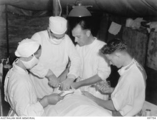 RABAUL, NEW BRITAIN, 1945-10-08. CAPT W.J. STONEY, DENTAL SECTION, 105 CASUALTY CLEARING STATION, EXTRACTING A BADLY DECAYED AND ABSCESSED TOOTH. HE IS ASSISTED BY SISTER M.H. JONES