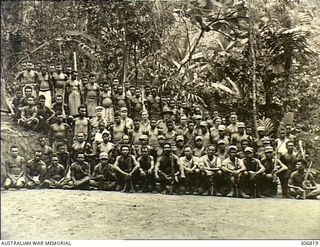 Bougainville, Solomon Islands. c. 1944-02. Group portrait of Coastwatchers and native police, some of whom are armed with rifles. Fourth back row, left to right: two native policemen; Flight ..