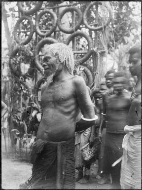 Chief in front of rings of village wealth, currency, Toma, New Guinea, ca 1929 / Sarah Chinnery