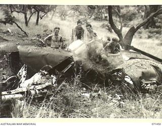 PIONEER CROSSING, PORT MORESBY AREA, PAPUA, 1944-03-25. AUSTRALIAN SERVICEMEN AT THE WRECK OF A P-38 LIGHTNING FIGHTER AIRCRAFT OF THE UNITED STATES ARMY AIR FORCE WHICH CRASHED IN TIMBERED AREA ..