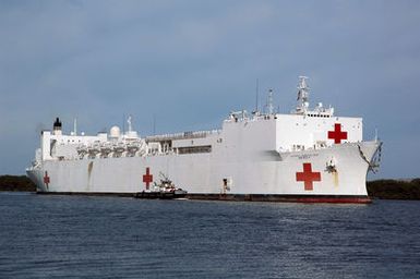 A starboard bow view showing the US Navy (USN) Military Sealift Command (MSC) Hospital Ship, USNS MERCY (T-AH 19), being assisted by a commercial tugboat as it arrives at Pearl Harbor, Hawaii (HI), for a scheduled port visit. The MERCY is en route to its homeport of San Diego, California (CA), after taking part in Operation UNIFIED ASSISTANCE, the humanitarian operation effort in response to the Tsunami that struck Southeast Asia