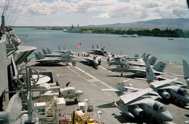 View from pri-fly (Primary Flight Control), looking aft at the flight deck of the nuclear-powered aircraft carrier USS ABRAHAM LINCOLN (CVN 72). Aircraft visible include F-14B Tomcat aircraft, S-3A Viking and an E-2C Hawkeye. The LINCOLN is in port to take part in Operation RIMPAC 2000