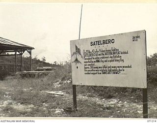 FINSCHHAFEN AREA, NEW GUINEA, 1944-03-17. ONE OF MANY BATTLE SIGNS IN THE FINSCHHAFEN AREA, THIS SIGN RECORDS THE SITE AT WHICH THE AUSTRALIAN FLAG WAS RAISED FOLLOWING THE CAPTURE OF SATTELBERG