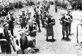 BOUGAINVILLE ISLAND. 1945-02-17. TROOPS OF THE 61ST INFANTRY BATTALION ON THEIR ARRIVAL AT MEIVO JUNCTION FROM THE MARERI RIVER FOR THE UNIT RENDEZVOUS WITH THE 9TH INFANTRY BATTALION. IDENTIFIED ..