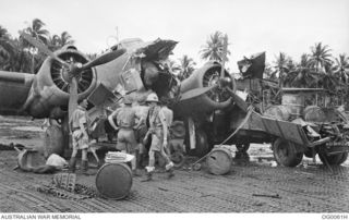 MILNE BAY, PAPUA. C. 1942-10. RAAF PERSONNEL INSPECT A DAMAGED HUDSON BOMBER AIRCRAFT OF NO. 6 SQUADRON RAAF WHICH HAD BEEN STRUCK BY A BEAUFIGHTER AIRCRAFT OF NO. 30 SQUADRON RAAF WHICH WAS ..