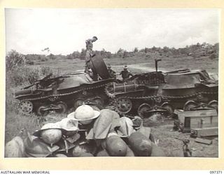 KAHILI AIRSTRIP, BOUGAINVILLE. 1945-09-28. JAPANESE TYPE 95 HA-GO LIGHT TANKS ON KAHILI AIRSTRIP AFTER BEING DESTROYED BY THE AUSTRALIAN DISPOSAL BOARD; BOMBS AND MINES IN THE FOREGROUND WILL BE ..