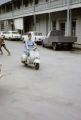 French Polynesia, woman riding scooter in Papeete