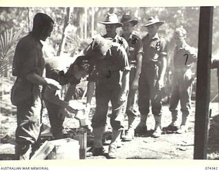 SIAR, NEW GUINEA. 1944-06-25. TROOPS OF THE 57/60TH INFANTRY BATTALION RECEIVING THEIR ISSUE OF COFFEE AND BISCUITS AT THE UNIT RECREATION TENT. IDENTIFIED PERSONNEL ARE:- VX141796 PRIVATE D.E. ..