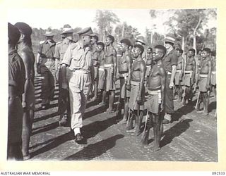 BOUGAINVILLE. 1945-05-23. BRIGADIER J.R. STEVENSON, COMMANDER 11 INFANTRY BRIGADE (1), INSPECTING NATIVE TROOPS OF A COMPANY, PAPUAN INFANTRY BATTALION, AFTER THEIR ARRIVAL IN THE SORAKEN AREA. THE ..
