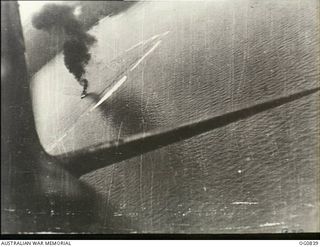 OFF THE NORTH COAST OF NEW BRITAIN. 1944-03-03. A BEAUFIGHTER AIRCRAFT OF NO. 30 SQUADRON RAAF ZOOMING UP AFTER AN ATTACK WITH SMOKE FROM STRAFED JAPANESE BARGE VISIBLE BELOW