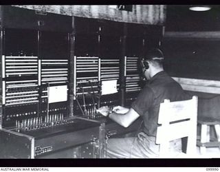 RABAUL, NEW BRITAIN, 1946-04-13. SIGNALMAN V. J. WALTERS OPERATING THE MAIN TELEPHONE SWITCHBOARD AT HQ 8 MILITARY DISTRICT