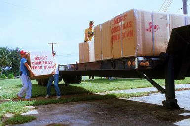 Volunteers from the 605th Military Airlift Support Squadron, the Andersen Air Force Base Leadership School, and the Navy position boxes of donated items for Christmas Drop onto a truck. The annual airdrop is a humanitarian effort providing aid to needy islanders throughout Micronesia during the holiday season