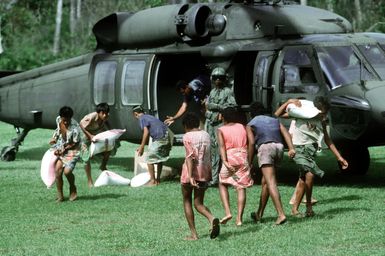 Villagers help unload supplies from a 53rd Aviation Battalion UH-60 Black Hawk helicopter following its arrival on the island of Savaii. Military personnel from the United States and other nations are providing such services to Savaii and the island of Upolu as part of disaster relief efforts in the aftermath of Cyclone Ofa