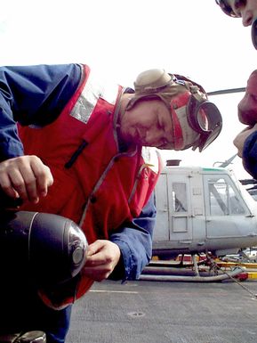 US Marine Corps GUNNERY Sergeant (GYSGT) Thomas M. Martinez cleans the lens on an AGM-114 Hellfire, short range, laser guided, air to surface missile mounted on an AH-1 Sea Cobra attack helicopter. On board the amphibious assault ship USS GUAM (LPH 9) currently in the Persian Gulf as part of an increased military presence to enforce UN sanctions against Iraq. Operation SOUTHERN WATCH, 21 February 1998